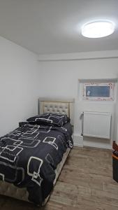 ein Schlafzimmer mit einem Bett mit einer schwarz-weißen Bettdecke in der Unterkunft Natur Atmosphäre in Netphen