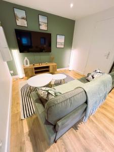 una sala de estar con un sofá y una mesa en Le Cocon Mévennais, en Saint-Méen-le-Grand 13 fotos más