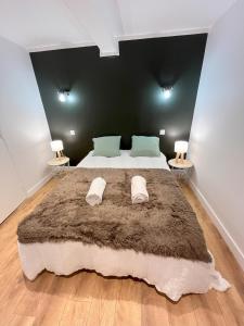 a bedroom with a large bed with a brown blanket at Le Cocon Mévennais in Saint-Méen-le-Grand