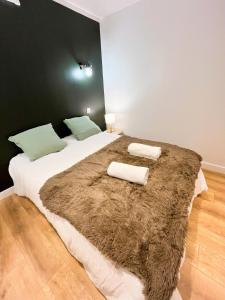 Un dormitorio con una cama grande con una manta marrón. en Le Cocon Mévennais, en Saint-Méen-le-Grand