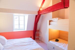 a bedroom with two bunk beds and a window at Mustard Hostel in Dijon