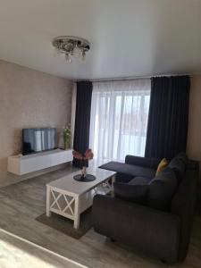 a living room with a couch and a table at Apartment in Telšiai