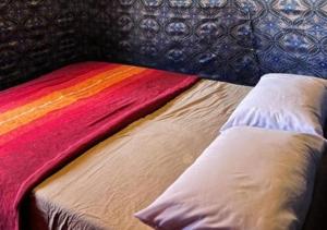 a bed with a colorful blanket on top of it at Sahara horizon Camp in Merzouga