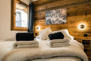 a bed with towels and two laptops on top of it at Centre Les Gets with 2 parking and Slope views - 6&2 ppl - Asteria in Les Gets