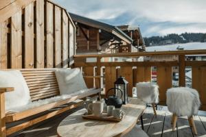 a wooden bench on a deck with a table at Centre Les Gets with 2 parking and Slope views - 6&2 ppl - Asteria in Les Gets