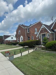a large brick house with a grass yard at Home Sweet Home in Detroit