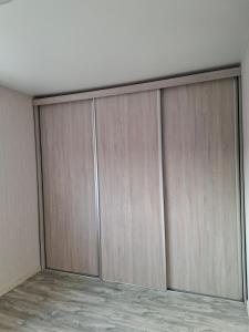 a row of wooden doors in a room at Apartment in Telšiai +2 photos
