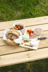 Una mesa de picnic con un sándwich y otros alimentos encima. en Parcel Tiny House - Lama Emoi 5 min du Zoo de Beauval, en Saint-Aignan 5 fotos más