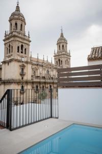 a building with a gate in front of a pool at Royar Casa del Reloj - Apartamentos Premium frente Catedral in Jaén