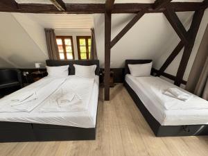 two beds in a room with wooden floors at Trobischhof in Dresden