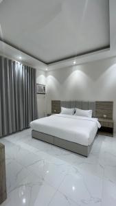 a bedroom with a large white bed in a room at شقق واڤا in Tabuk