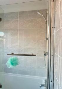 a shower with a glass door next to a tub at Bnb in Abbeymead