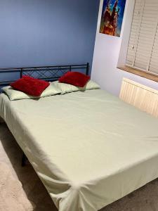 a bed with two red pillows on top of it at Bnb in Abbeymead