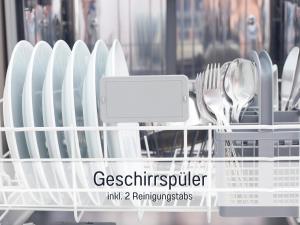 ein Geschirrständer voller Teller und Silberbesteck in der Unterkunft Komfortables Ferienhaus Strandzauber auf Fehmarn für 8 Personen mit 4 Schlafzimmern und 2 Bädern in Fehmarn