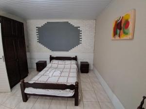 ein kleines Schlafzimmer mit einem Bett in der Ecke in der Unterkunft Espaço básico e funcional, privativo com 2 ambientes, sem fogão, zona nobre, com garagem in Pelotas