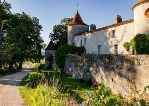 una vieja pared de piedra junto a un edificio en Parcel Tiny House Couronneau près du Périgord, en Ligueux