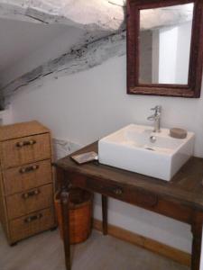 y baño con lavabo y espejo. en La Maison Bleue, en Brantôme