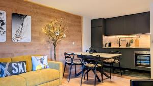 a living room with a couch and a table with chairs at Nendaz Nest - Appartement moderne & confortable au cœur de Nendaz - 4 Vallées in Nendaz