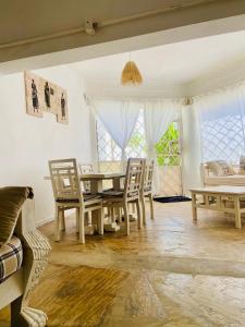 a dining room with a table and chairs and a window at Nautical Nest Beachfront Apartments in Malindi
