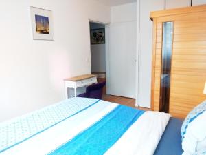 a bedroom with a bed and a desk and a bed at Apt au calme, 2-3 chambres, Sauna, 2 parkings, bus sur place in Montévrain