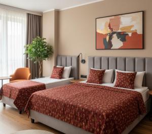 a hotel room with two beds and a chair at Trabzon Live Hotel in Bostancı
