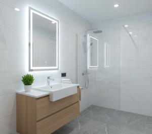 a white bathroom with a sink and a shower at Trabzon Live Hotel in Bostancı