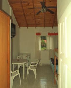 een kamer met een tafel en stoelen en een plafondventilator bij LalomitaGesell in Villa Gesell