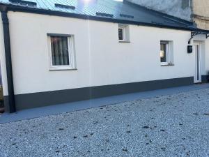 a white house with windows and a gravel driveway at Lux Stay Apartmant in Varaždin