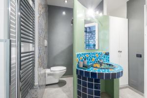 a bathroom with a toilet and a mosaic sink at DrsRome - Colosseum Loft in Rome +24 photos