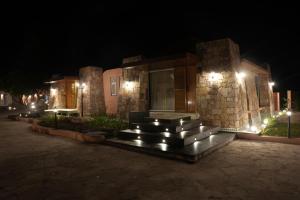 a building with a fountain in front of it at night at Wild Forest By Nirvana in Sasan Gir