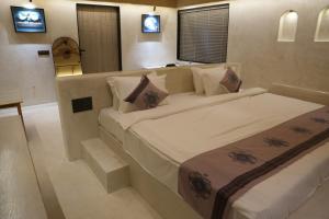 a bedroom with two beds and two televisions at Wild Forest By Nirvana in Sasan Gir