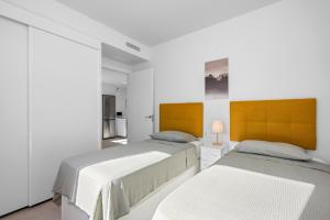 two beds in a room with white walls at Casa MardeSal in San Pedro del Pinatar +30 photos