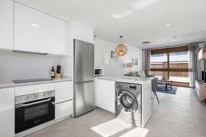 a white kitchen with a washing machine in it at Casa MardeSal in San Pedro del Pinatar