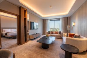 a hotel room with a living room with a bed and a couch at MOVENPICK HOTEL AL ZAYTOON BAGHDAD in Baghdad