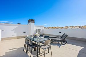 a patio with a table and chairs on a roof at Casa MardeSal in San Pedro del Pinatar