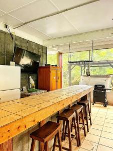 een grote keuken met een lange houten toonbank met barkrukken bij Sister River Retreat in Vernon