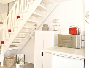 a kitchen with white stairs and a microwave at Freibeuter Appartement Nr 27 Scharbeutz in Scharbeutz