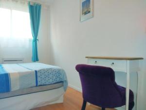 een slaapkamer met een bed, een bureau en een stoel bij Apt au calme, 2-3 chambres, Sauna, 2 parkings, wifi in Montévrain