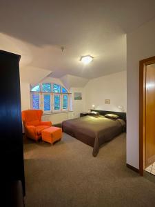 a bedroom with a bed and an orange chair at Parkhotel Essen in Essen