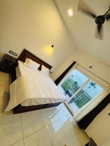 a bedroom with a bed and a large window at Ann Villa homestay in Anachal +9 photos