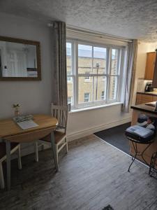 a dining room with a table and a window at Havisham Studio Flat Rochester ME1 1XZ in Strood
