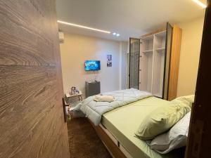 a small bedroom with a bed and a television at Four pyramids View Guest house in Cairo