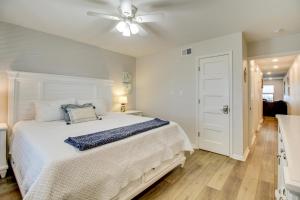 Un dormitorio con una cama blanca y un ventilador de techo. en Beach and Pool Access Port Aransas Condo with Balcony, en Port Aransas 16 fotos más