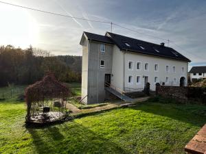 a large white house with a yard and a fence at Ferienwohnung Martha und Nikla in Philippsheim