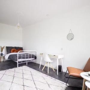 ein Schlafzimmer mit einem Bett, einem Schreibtisch und einem Tisch in der Unterkunft Dina Cozy House in Jakarta