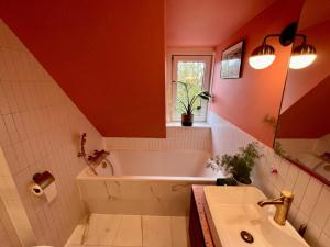 ein Badezimmer mit Badewanne und Waschbecken in der Unterkunft Dina Cozy House in Jakarta