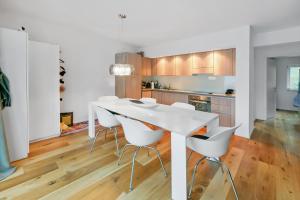 a kitchen with a white table and white chairs at Ferienwohnung Tgesa Sulai in Savognin