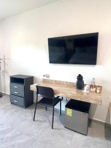 Elle comprend un bureau avec une chaise et une télévision murale. dans l'établissement Alux, à Bacalar