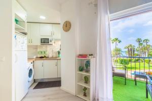 een keuken met witte kasten en een groot raam bij Apartamento Góndolas in Almuñécar