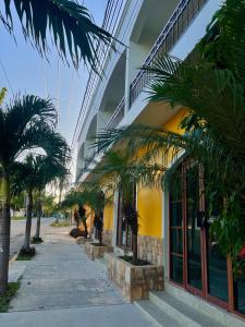 un bâtiment avec des palmiers devant dans l'établissement Alux, à Bacalar